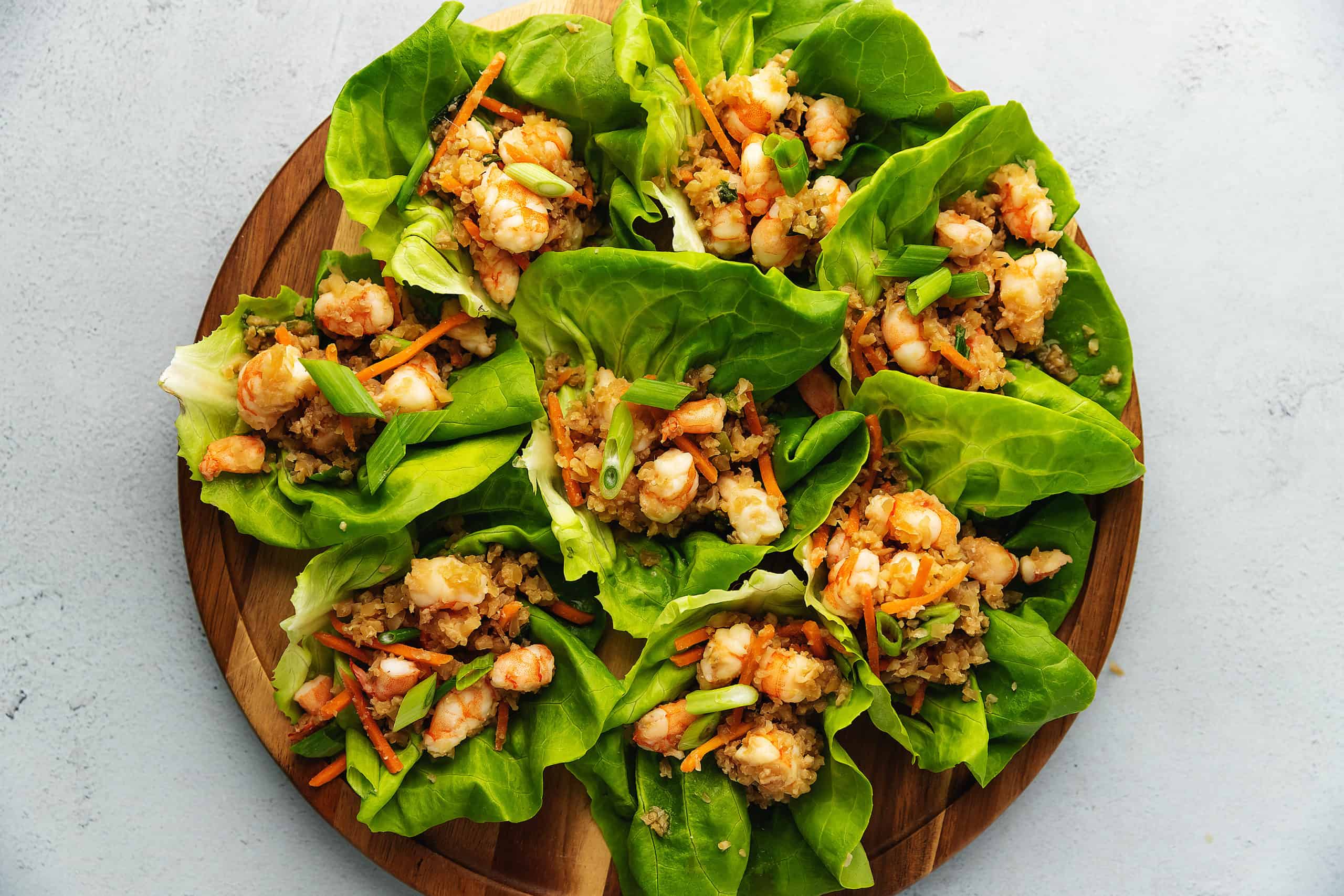 shrimp and cauliflower lettuce wraps on a wood platter