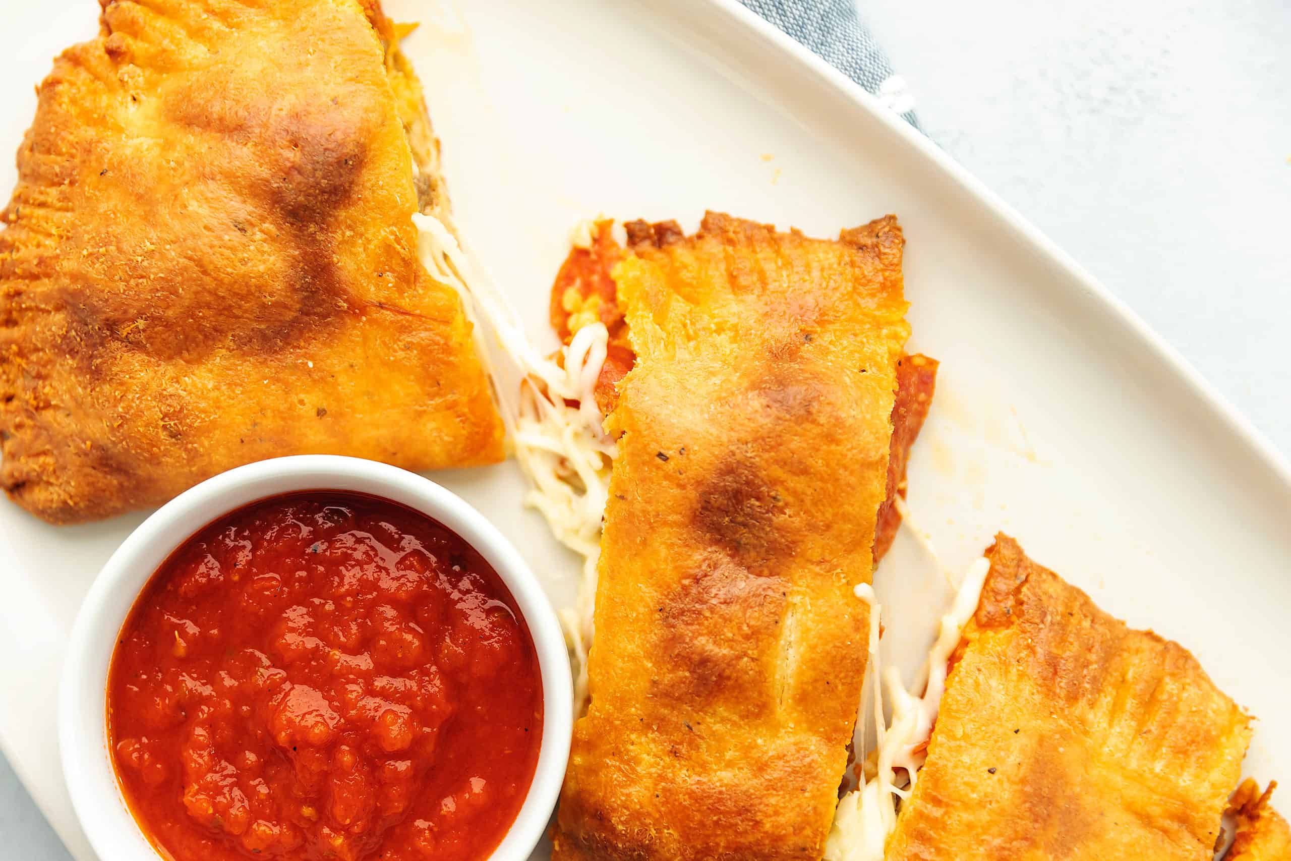 calzone on a white plate with marinara