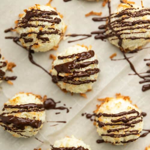 coconut macaroons drizzled with chocolate on a sheet tray