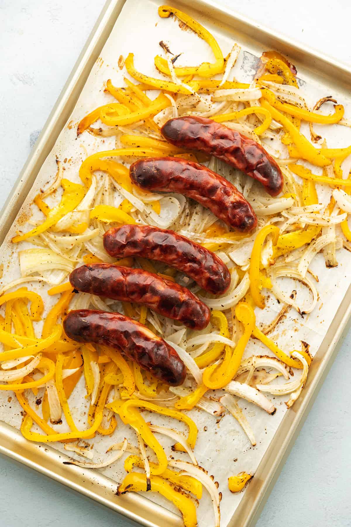 sausage and peppers on a sheet tray