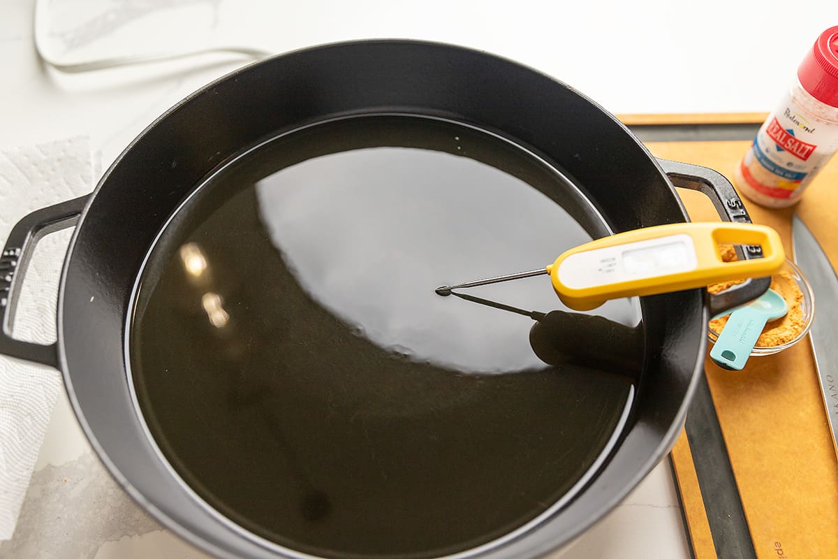 heating a large black skillet with oil for frying