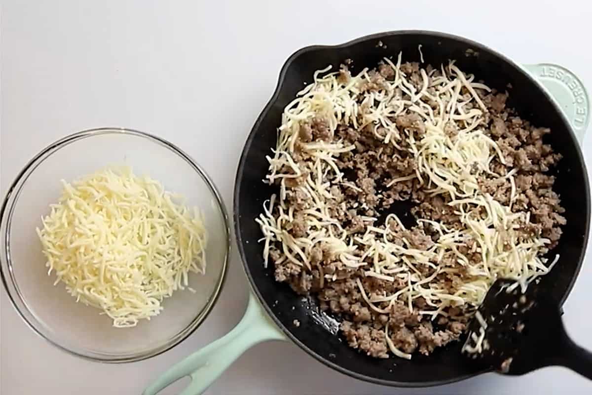 meat and cheese in the bottom of a skillet