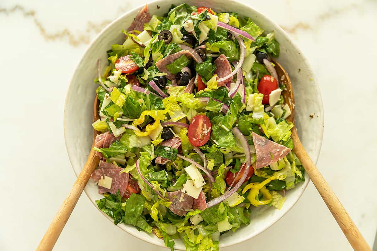 Italian chopped salad in a large bowl with salad tongs