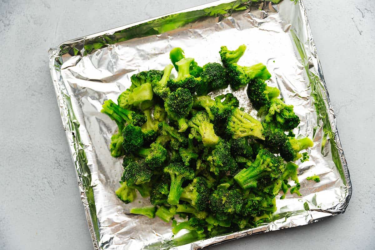 a bunch of frozen broccoli on an air fryer tray