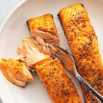 flaky frozen salmon in the air fryer on a white plate