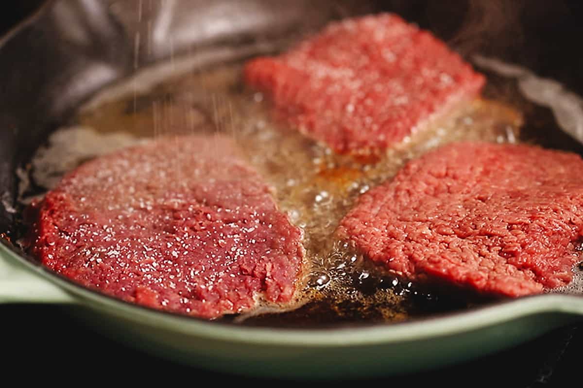 cubed steaks cooking in a skillet
