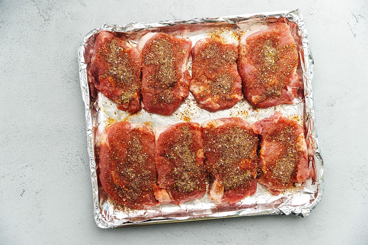 seasoned pork chops on an air fryer tray