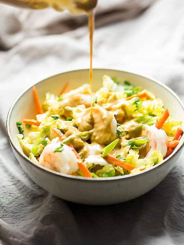 pouring dressing on a shrimp spring roll bowl