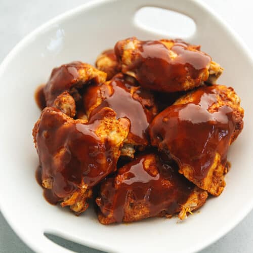 bbq chicken thighs in a white bowl