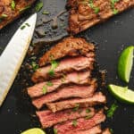 skirt steak on a cutting board with lime wedges