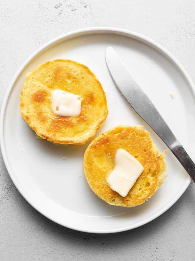 keto English muffins on a white plate with butter and a knife