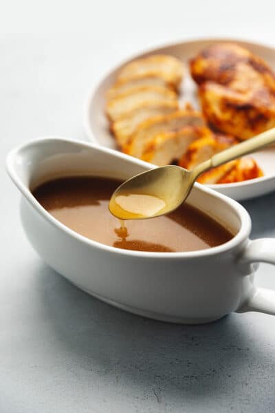 easy keto gravy in a gravy boat with a gold spoon