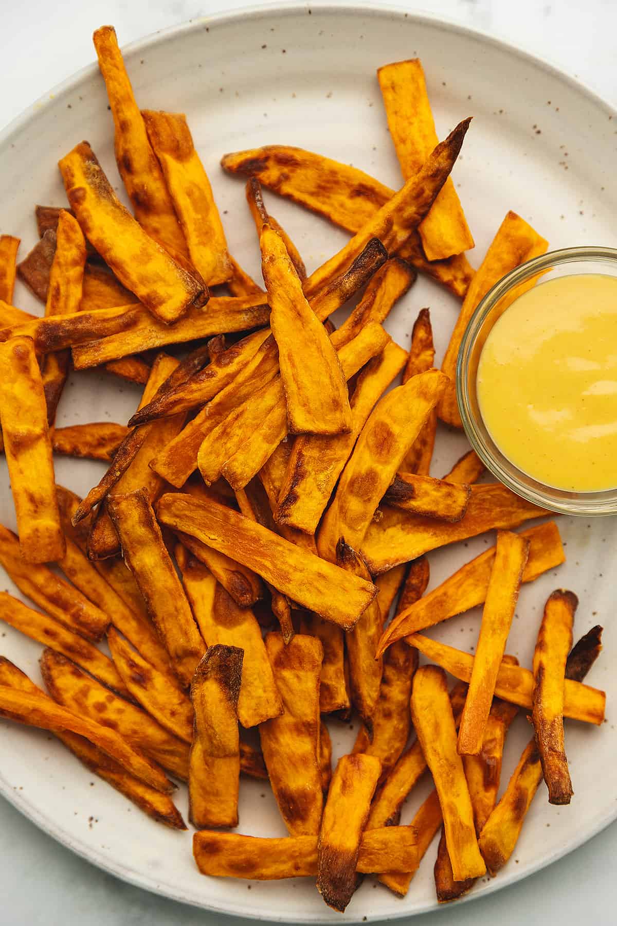 crispy sweet potato fries on a plate with honey mustard