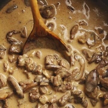 creamy mushroom and beef sauce with a wooden spoon