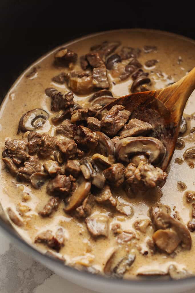 keto beef stroganoff in a pot with a wooden spoon
