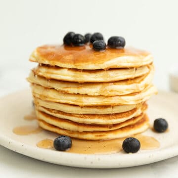 protein pancakes with blueberries and syrup on a white plate