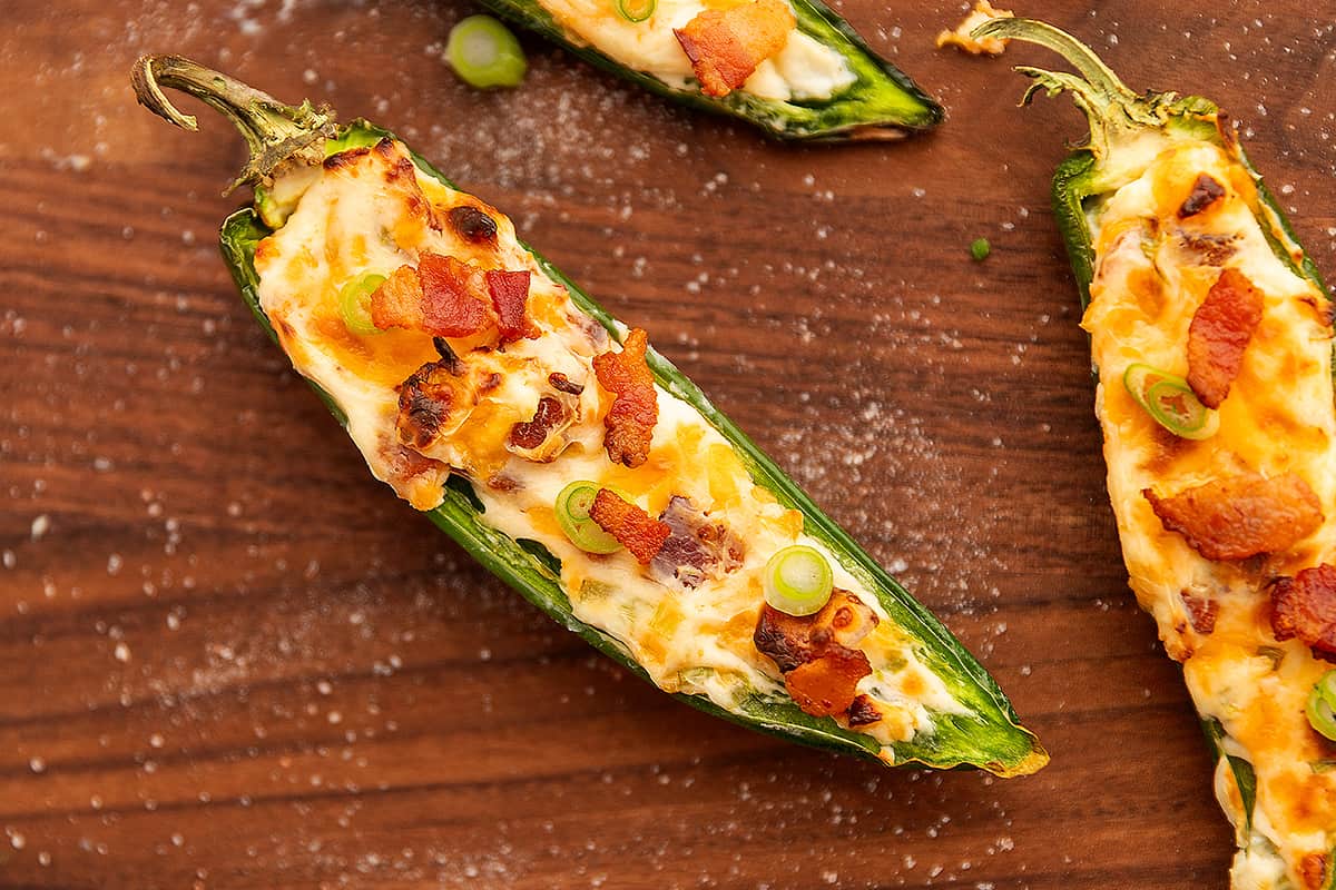 a cooked jalapeno popper on a wooden cutting board 