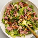 Jennifer aniston salad in a white bowl with a gold fork