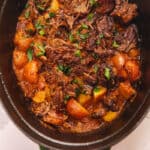 a staub dutch oven with roast and potatoes