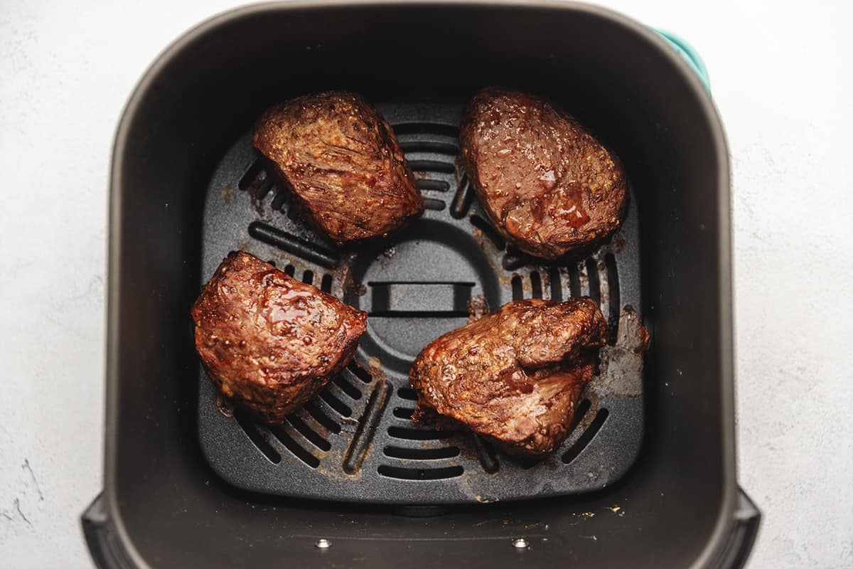 cooked steaks in the air fryer basket