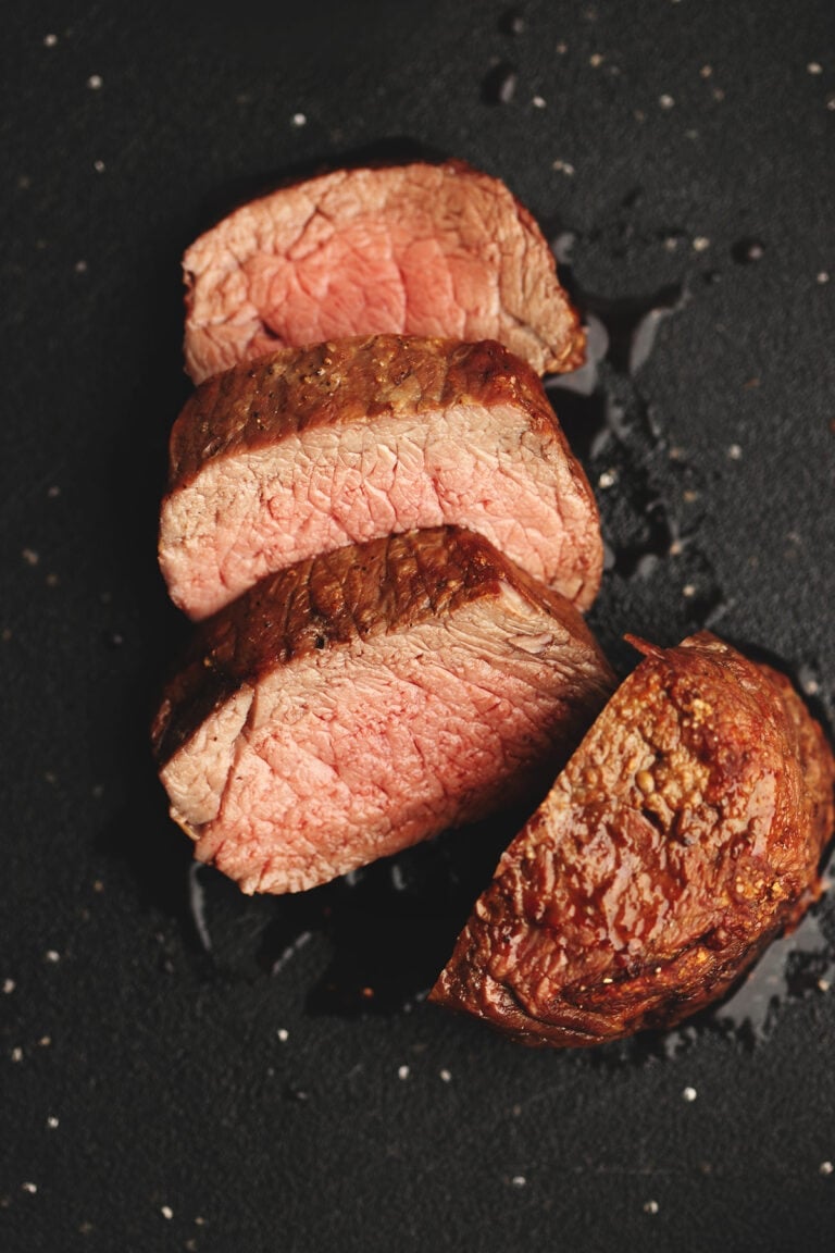 air fryer filet mignon on a black cutting board