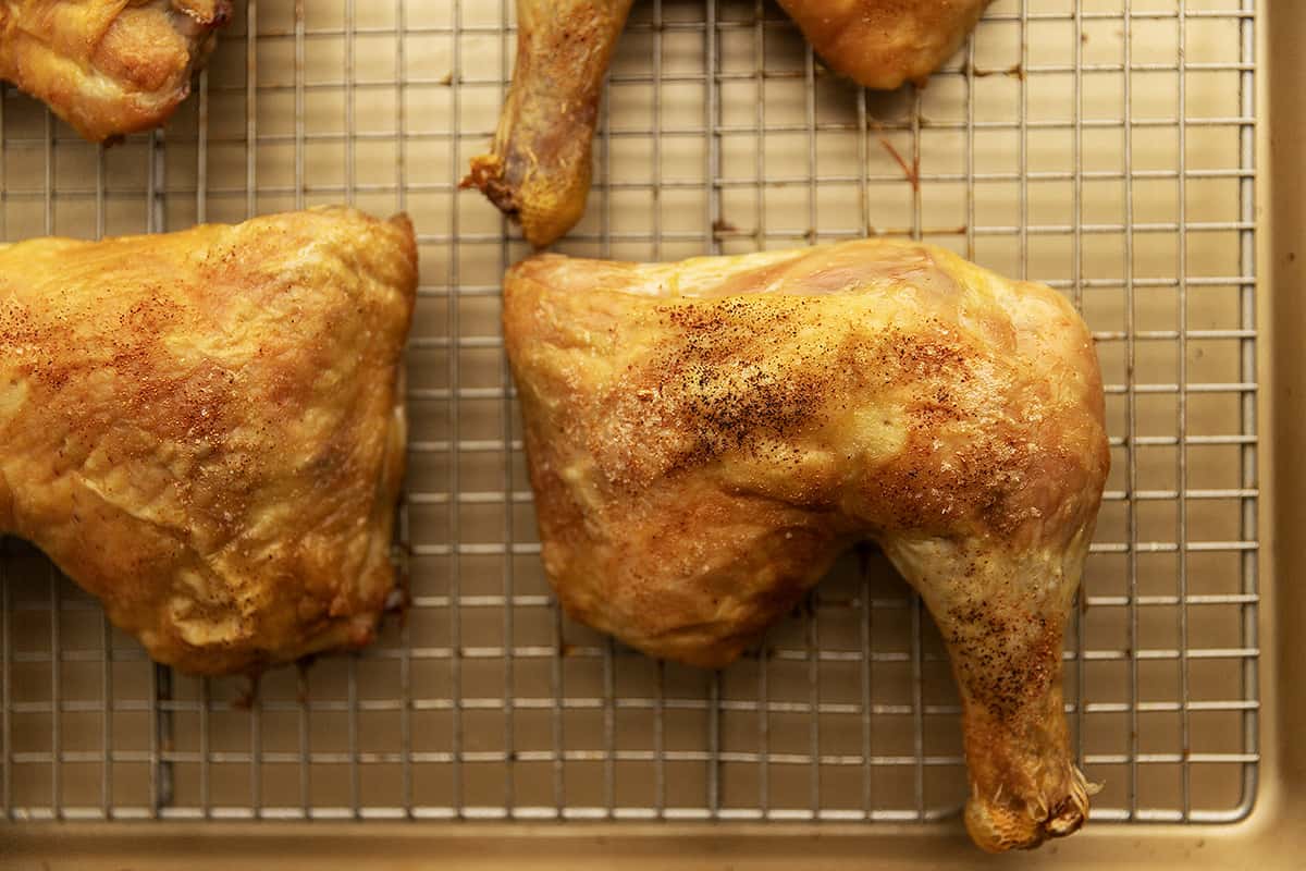 crispy baked chicken leg quarters on a wire rack