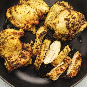 pesto marinated chicken thighs cooked in a skillet