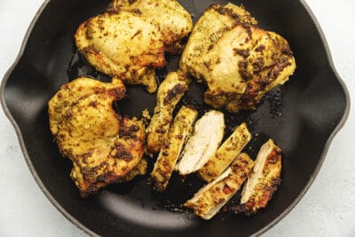 pesto marinated chicken thighs cooked in a skillet