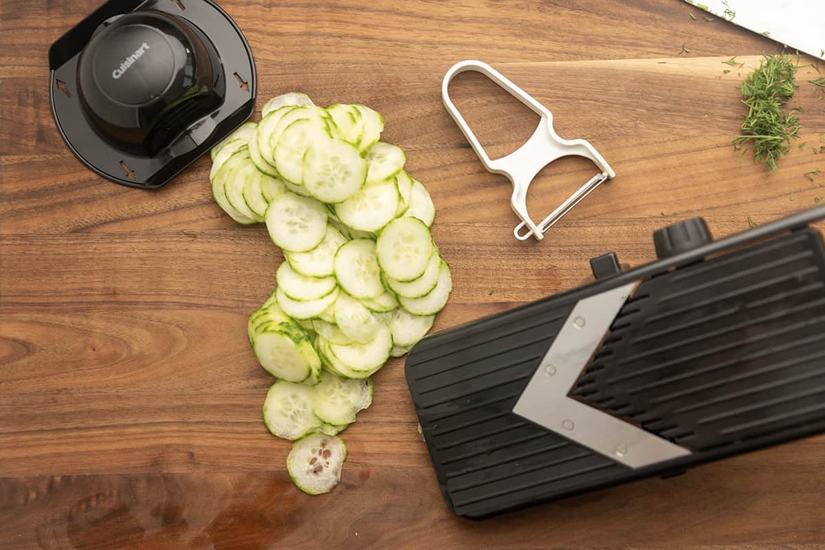 thinly sliced cucumbers on a cutting board 
