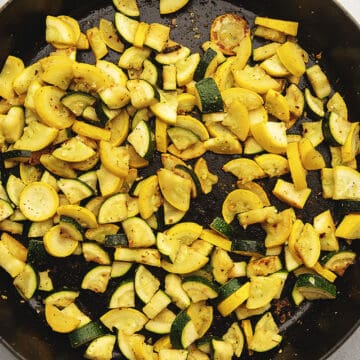 summer squash and zucchini sautéed in a large black skillet
