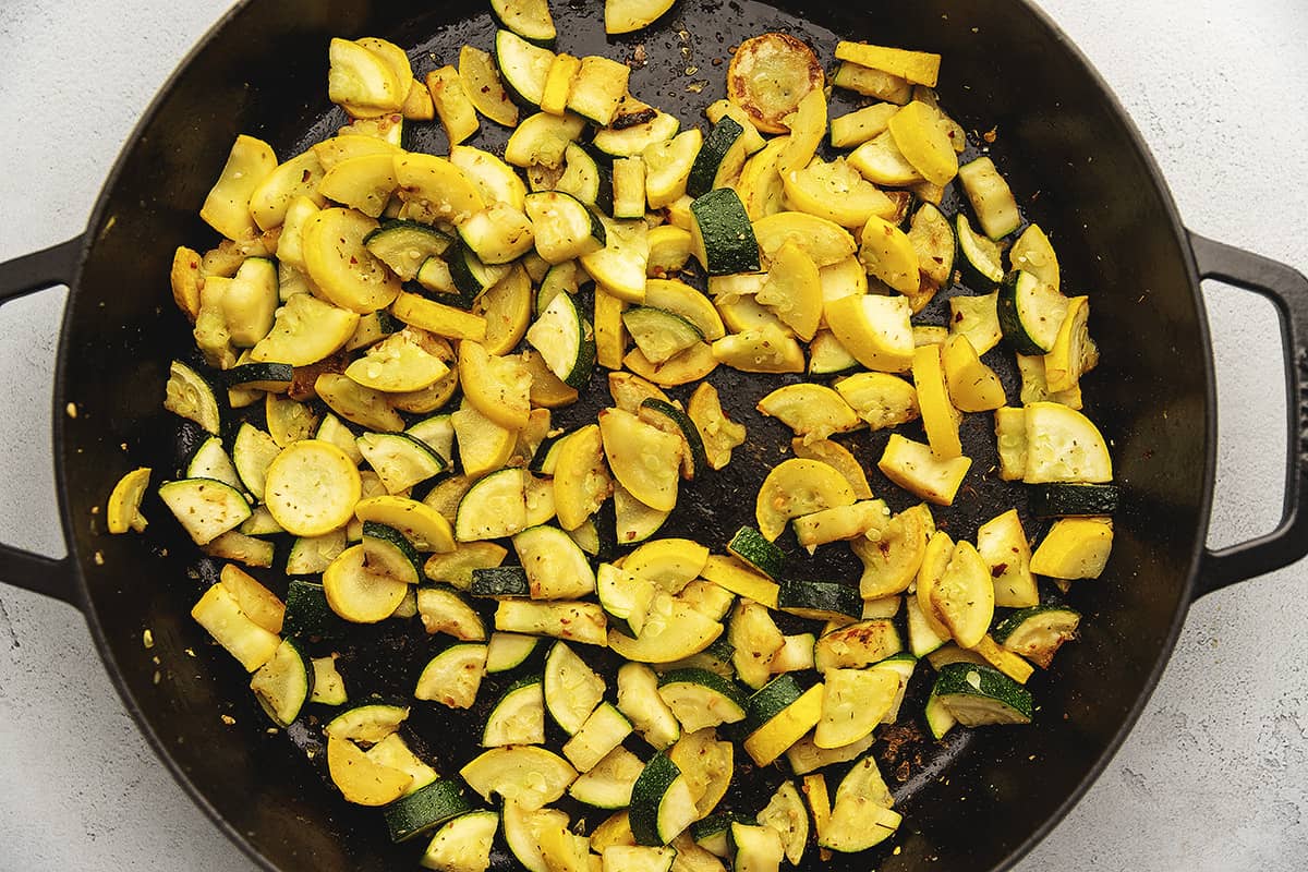 summer squash and zucchini sautéed in a large black skillet