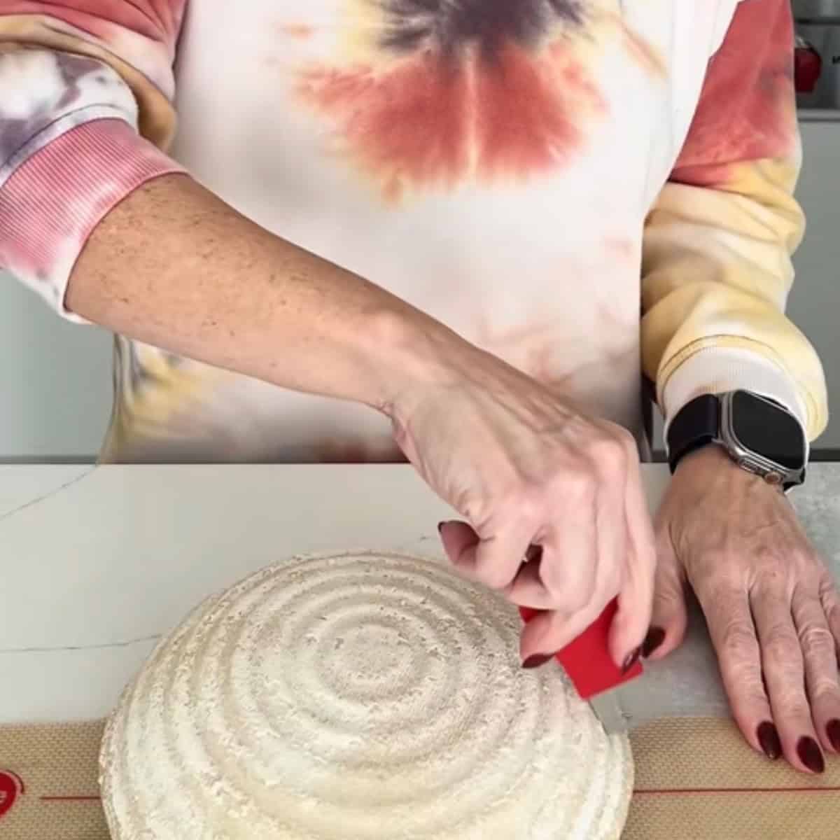 scoring a loaf of sourdough bread