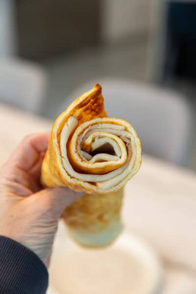holding a rolled up cottage cheese flatbread