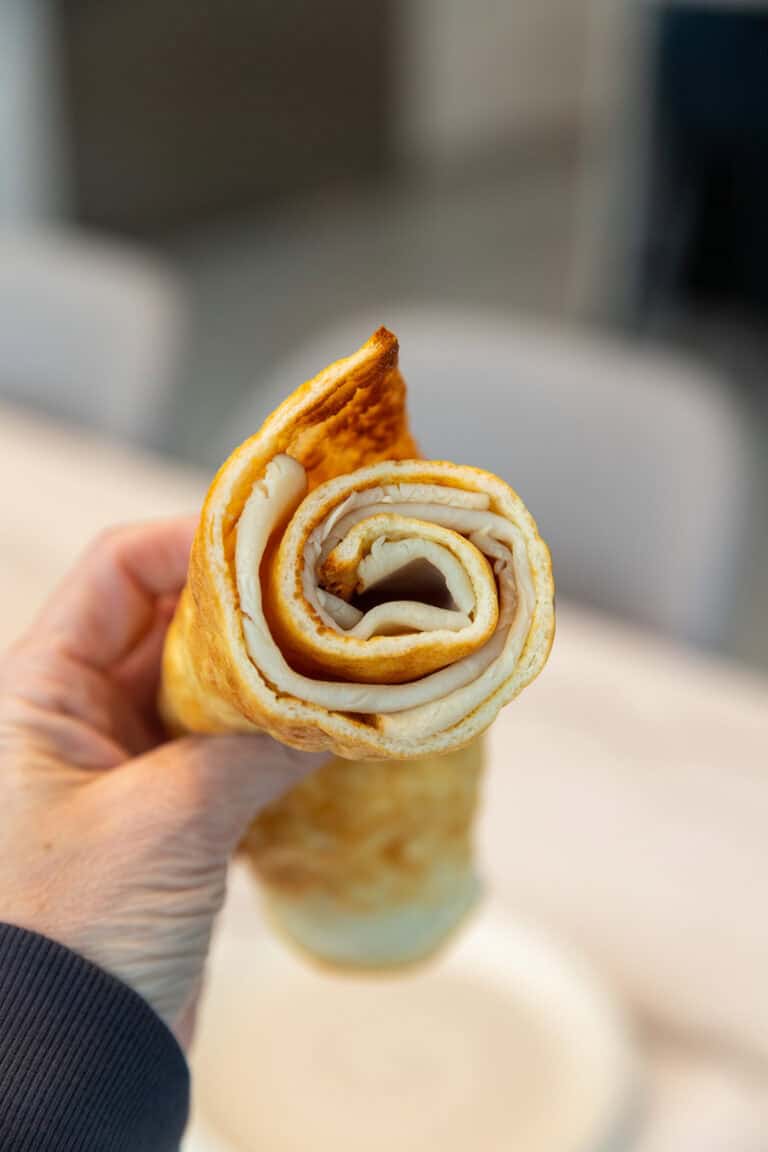 holding a rolled up cottage cheese flatbread