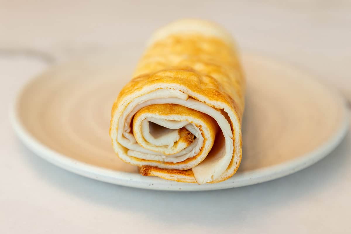 a flatbread wrap made with cottage cheese rolled up on a plate