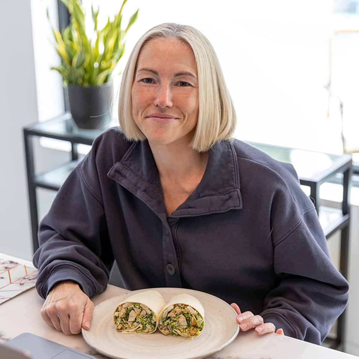 Jennifer sitting at the table with a wrap on a plate