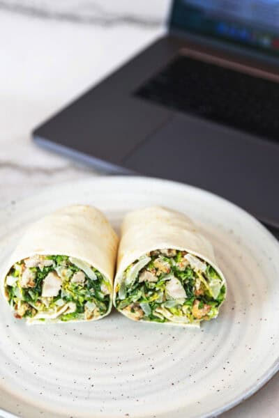 chicken caesar wrap in front of a laptop