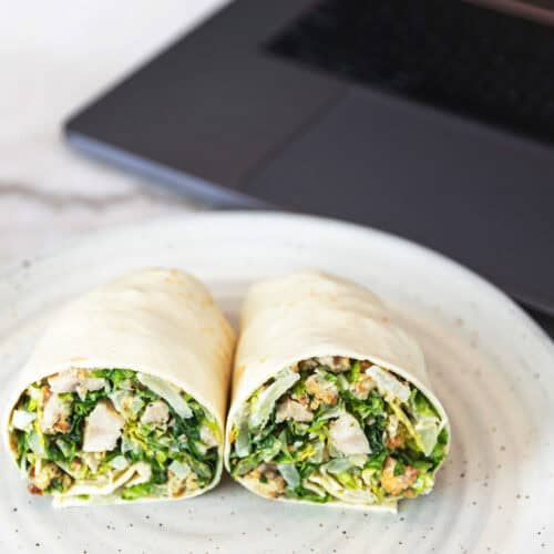 chicken caesar wrap in front of a laptop
