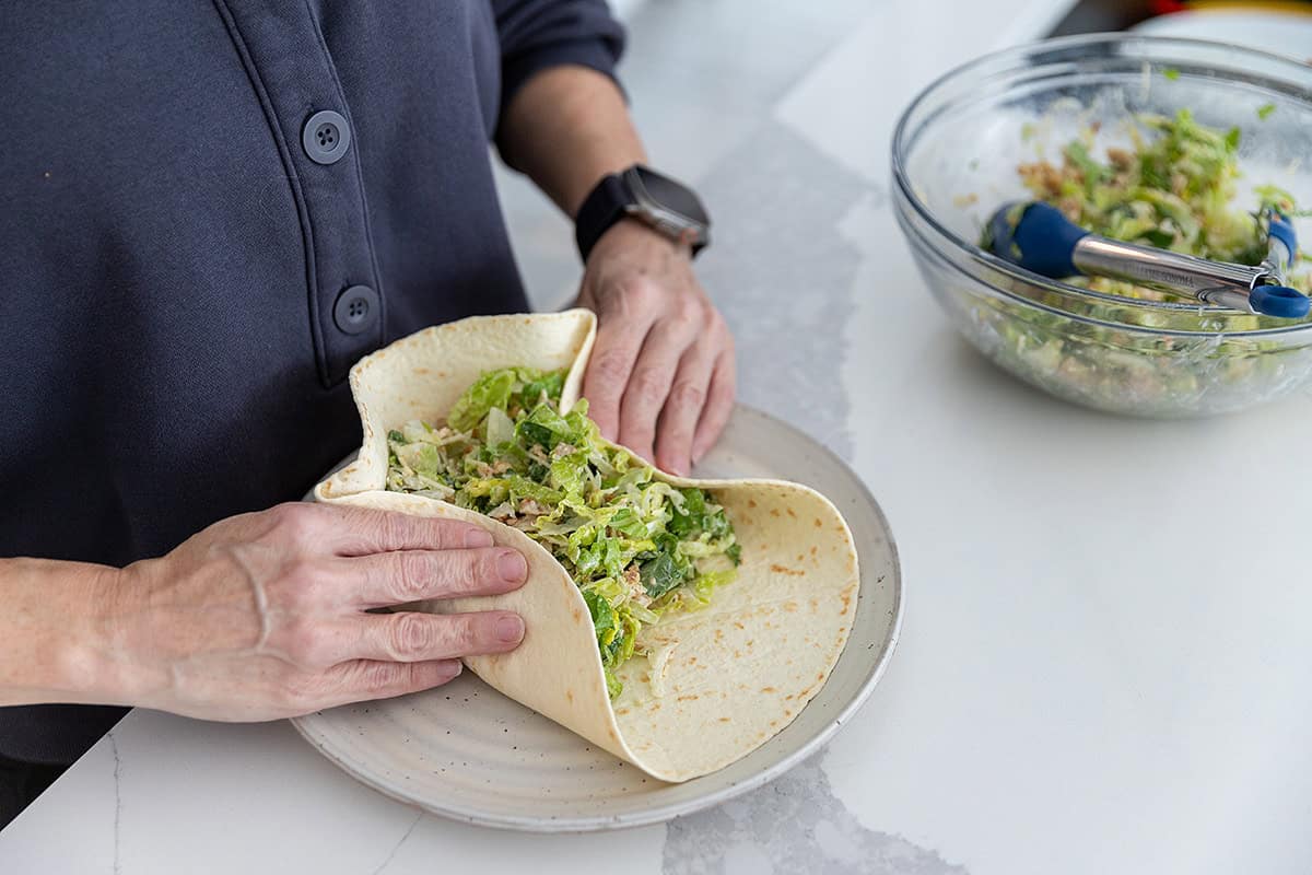 folding a chicken caesar salad wrap