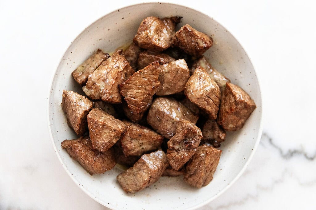 finished air fryer steak bites in a white bowl