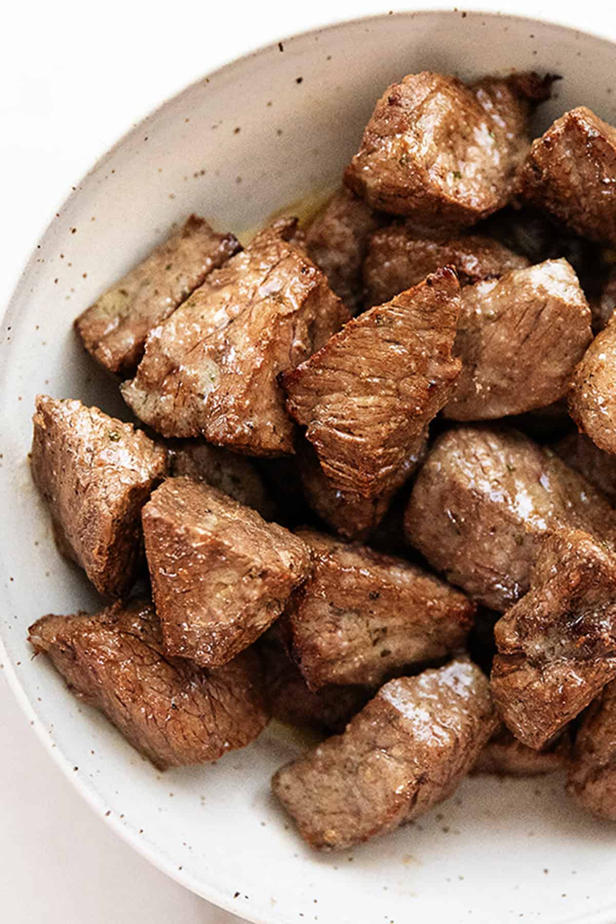 a bowl full of air fryer steak bites with garlic butter