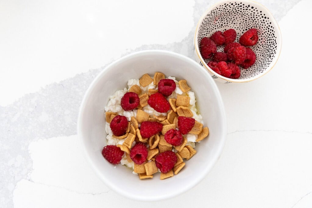 a bowl with cottage cheese, Catalina crunch cereal, and raspberries