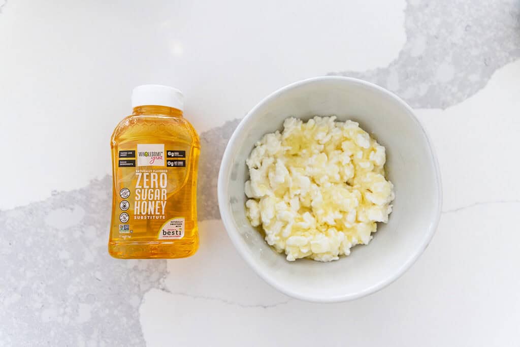 a white bowl with cottage cheese and wholesome yum honey substitute