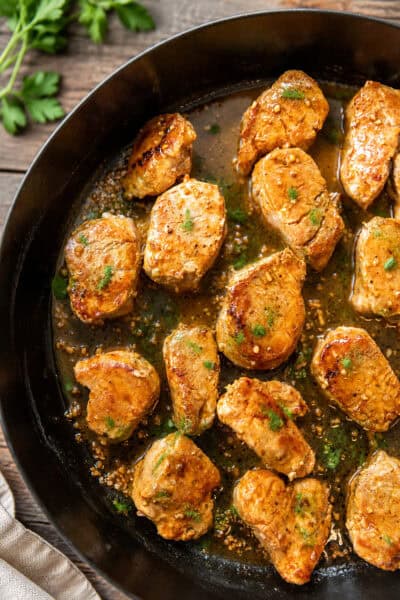 Pork medallions in garlic butter sauce in a skillet