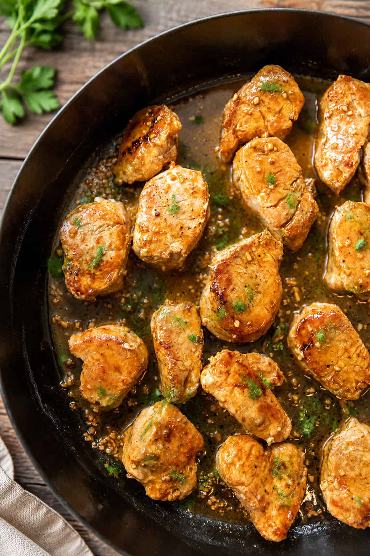 Pork medallions in garlic butter sauce in a skillet