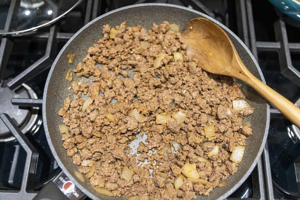 ground beef and onions cooking in a skillet